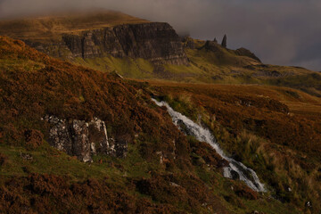 Small waterfall and the Old man of Storr at Skye Island, Scotland