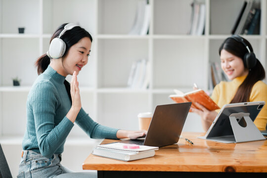 Two women using digital devices for online learning and communication in a cozy home office environment.