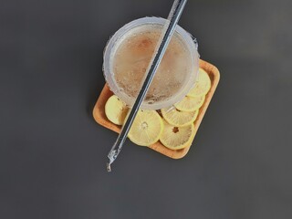 iced lemon tea packaged in a plastic cup on a black background