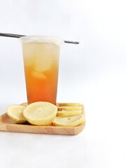 iced lemon tea packaged in a plastic cup on a white background