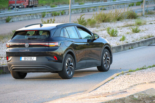 Black volkswagen id.4 driving on asphalt road near highway