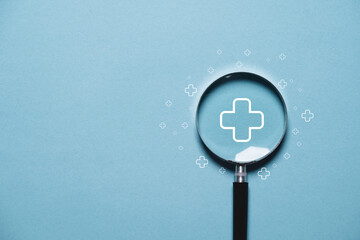 White plus sign inside magnifier glass on blue background for focus positive thinking mindset of...