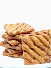 delicious freshly baked chocochip cookies on a plate isolated over white background.sugar chocolate biscuits stacked.sweet foods cause diabetes.tempting tasty baked cookies ready to be served.