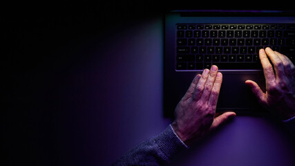 Male hands are typing on a laptop keyboard.