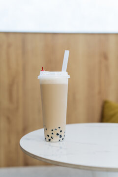 Close-up of a cappuccino bubble coffee with tapioca pearls on a table