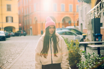 A Young Woman Walking in an Urban Street Surrounded by a Beautiful Sunlight Glow