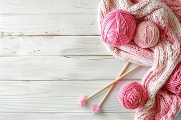 A wooden table with a knitted blanket and a pair of knitting needles