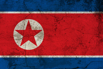 The North Korea flag painted on cracked ground with vignette. Nort Korea Independence Day 15th of August.