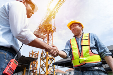 Group of male engineer construction putting their hands together at construction site. Teamwork of male construction builder at construction site. Unity and teamwork concept
