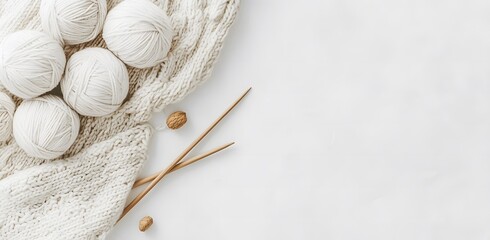 A serene and relaxing scene with soft balls of yarn in different colors, arranged one on top of the other with needles next to each other. Highlighting handicrafts to increase people's interest.