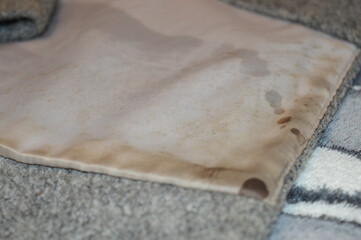 hand holding spray bottle against grey wool coat black buttons clothing care cleaning removing stains freshening fabrics household chores cleaning products winter seasonal clothing hacks solutions