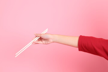 hand holding plastic chopsticks