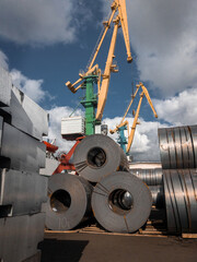 Rolls of hot rolled steel in stock. Stacks of steel sheet rolls in the port, cold rolled steel rolls. A roll of sheet iron. Hot rolled steel rolls are stored outdoors.