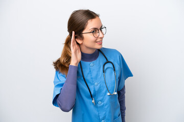 Young caucasian nurse woman isolated on white background listening to something by putting hand on the ear
