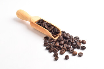 Obraz premium Roasted coffee beans in wooden spoon isolated on white background