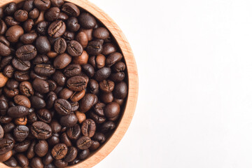 Roasted coffee bean in wooden bowl isolated on white background. Top view. Flat lay. Cop space. Close up