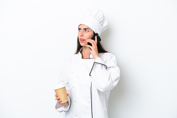 Young chef woman over white background holding coffee to take away and a mobile