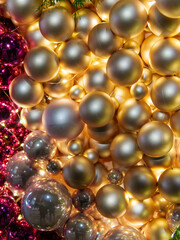 A vibrant display of gold and silver ornaments is adorned with soft lights, creating a festive atmosphere perfect for celebrations, showcasing a blend of shimmering textures and colors.