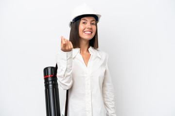 Young architect woman with helmet and holding blueprints isolated on white background making money...