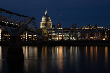Fototapeta premium Night view of London's iconic Millennium Bridge leading to Saint Paul's Cathedral across the Thames river