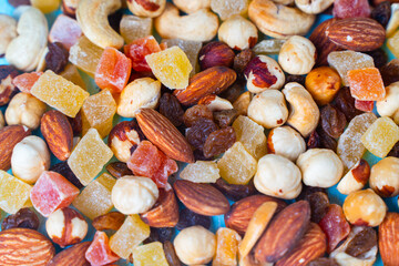 Background with the texture of a mixture of various nuts and candied fruits. Close-up