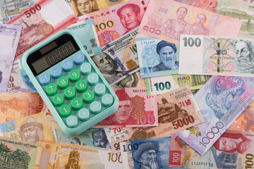 Calculator against the background of different banknotes from different countries of the world