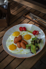Breakfast scrambled eggs and sausages on the summer terrace