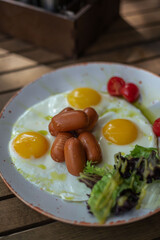 Breakfast scrambled eggs and sausages on the summer terrace