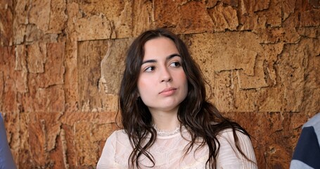 Young woman posing confidently in a cozy restaurant setting. Portrait of confident young woman in stylish restaurant, radiating elegance and charm during casual gathering. Beautiful and young woman