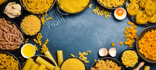 Pasta banner. Bowls with different types of raw Italian pasta. Free space for text. Top view.