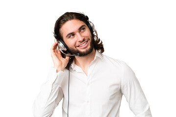 Telemarketer man working with a headset over isolated chroma key background thinking an idea