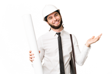 Young architect man with helmet and holding blueprints over isolated chroma key background extending hands to the side for inviting to come