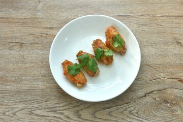 crispy fried salty and spicy chicke wing topping parsley on plate