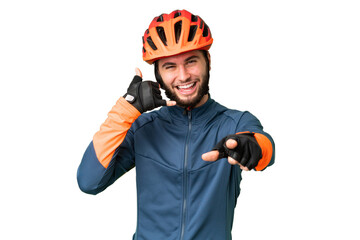 Young cyclist man over isolated chroma key background making phone gesture and pointing front