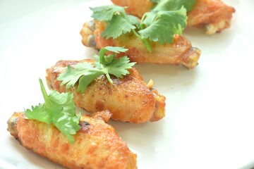 crispy fried salty and spicy chicke wing topping parsley on plate