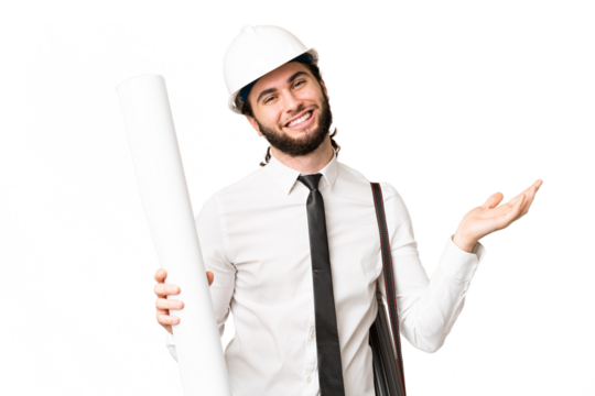 Young architect man with helmet and holding blueprints over isolated chroma key background extending hands to the side for inviting to come