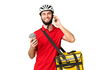 Young delivery man with thermal backpack over isolated chroma key background holding coffee to take away and a mobile