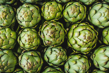 Fototapeta premium Fresh green artichokes displayed at a local market on a sunny day