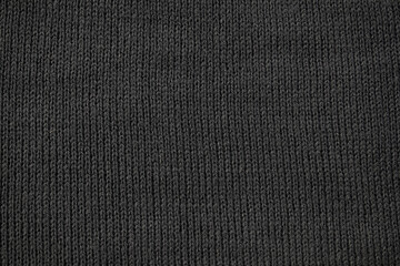 Detailed dark grey knitted fabric background texture.