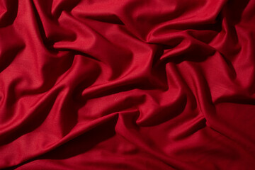 Fototapeta premium Crumpled wavy Red silky fabric background texture. siny and glossy.