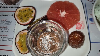 Assiette composé de desserts dont grenadier, pamplemousse, verrine de mousse au chocolat et gâteau 