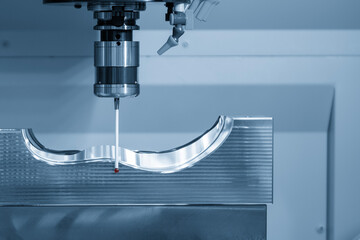 The CMM probe measuring the  mold parts on machining center in the light blue scene.