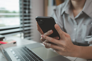a businesswoman is using an electronic device to search and send information to her team, the marketing team leader is reviewing documents related to marketing data