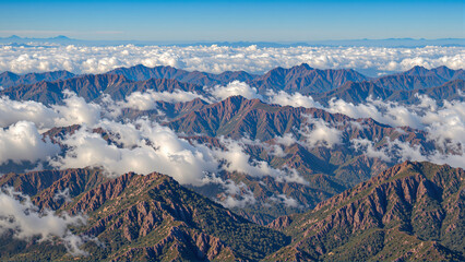 Fototapeta premium Breathtaking mountain landscape with clouds floating over peaks during a sunny day