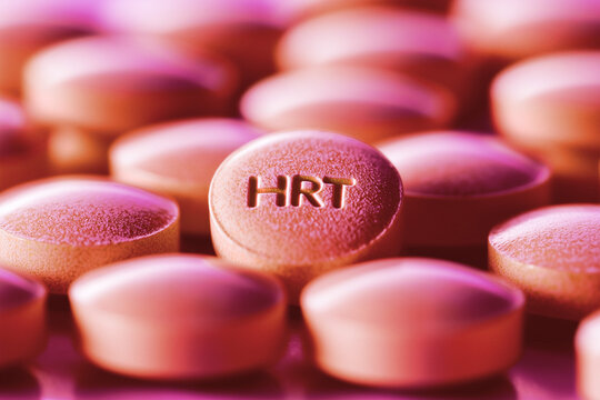 pile of pink HRT pills close up, hormone replacement therapy for menopause symptoms, orange light