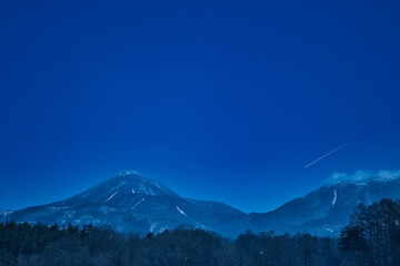 雪の蓼科山の青く嫌いな夜景と流れ星