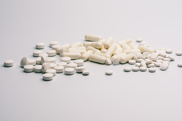 Assorted White Pills and Capsules on White Background