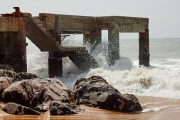 Ancient ruined maritime structure hit by strong waves.
