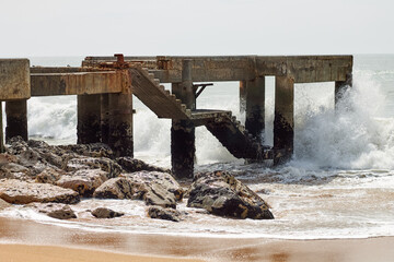 Ancient ruined maritime structure hit by strong waves.