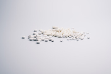Assorted White Pills and Capsules on White Background